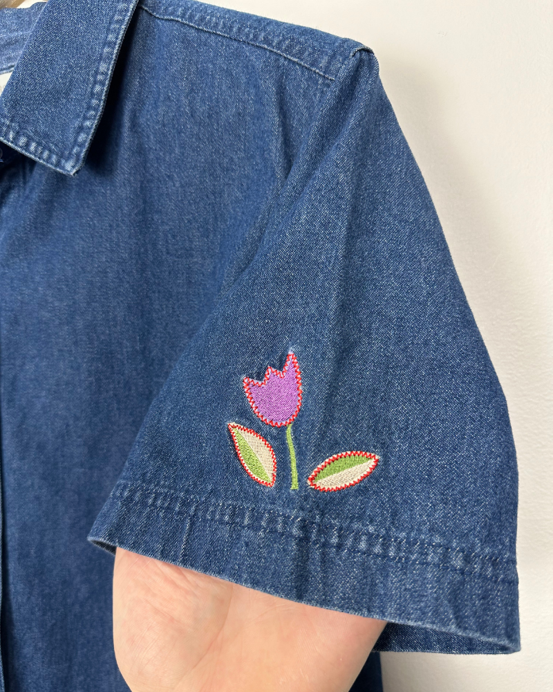 
                  
                    Vintage East West Tulip Flower Embroidered Women's Grandma Denim Shirt - Size L
                  
                